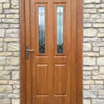 uPVC entrance door in golden oak with decorative glass panels and silver hardware